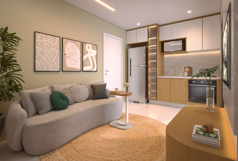 Sala de estar com sofá curvo bege, cozinha integrada com forno embutido e quadros decorativos